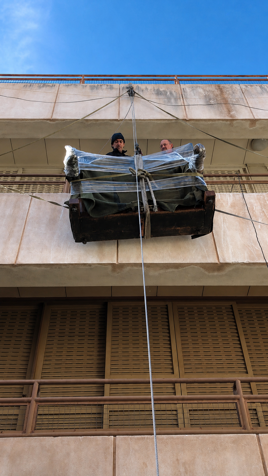 Mueble elevado desde la calle hasta un balcón con sogas y aparejos