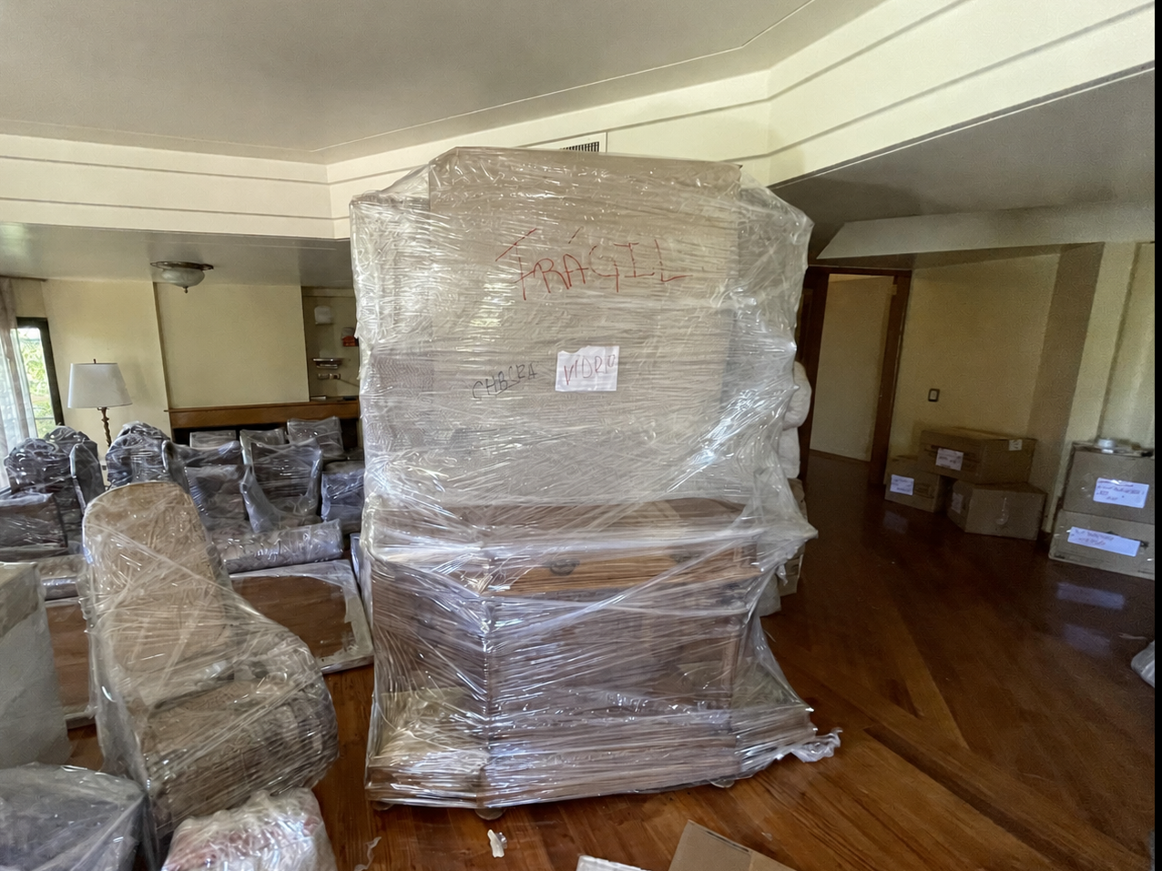 Mueble voluminoso y sillas protegidos antes de comenzar la mudanza