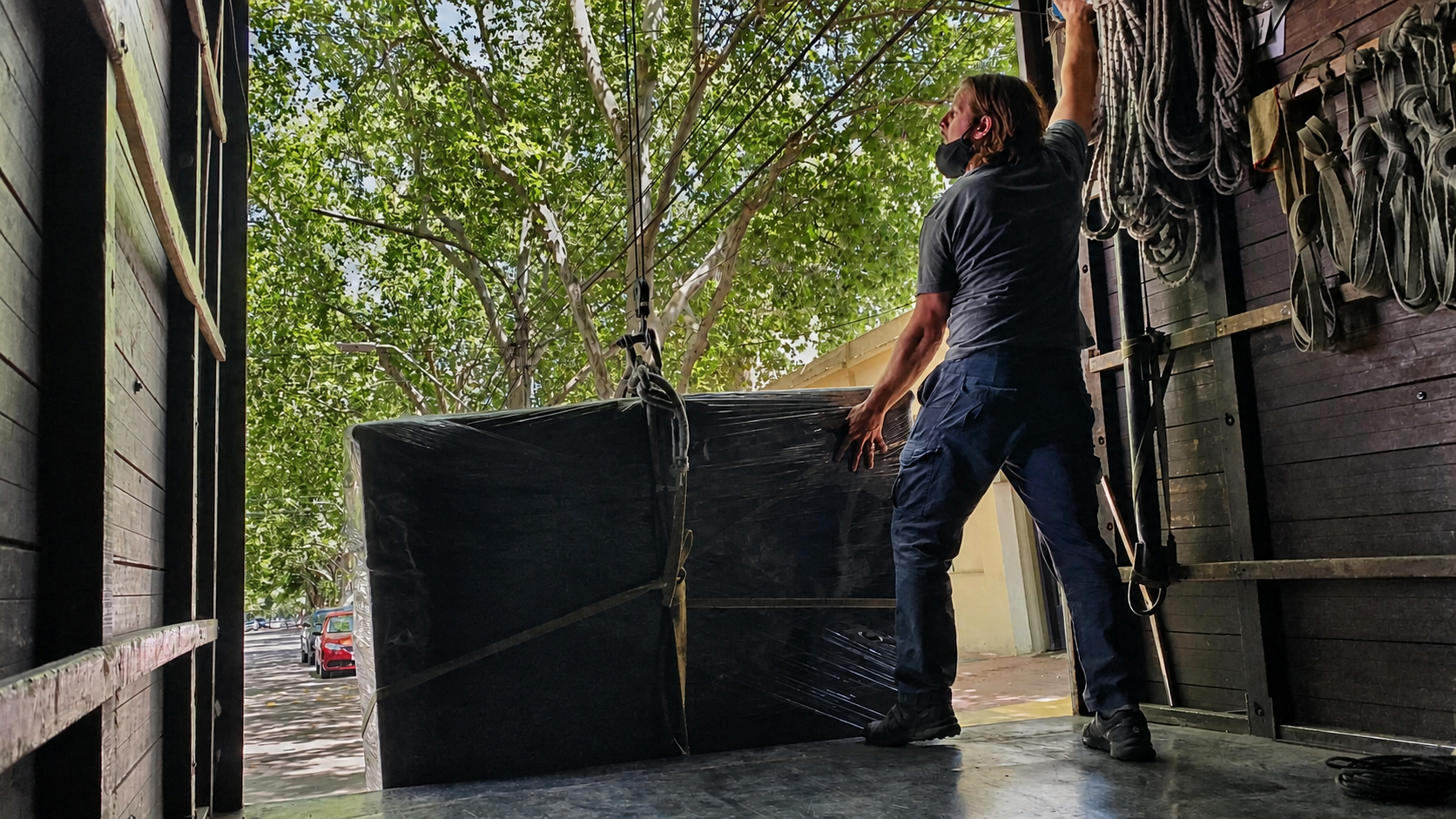 Trabajador de Mudanzas Stocco guiando un mueble protegido durante la carga al camión